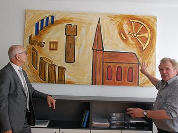 Künstler Herbert "Jimmy" Fell (rechts) erläutert Bürgermeister Richard Knaier seine Inspirationen für sein Bild, das im Zimmer des Bürgermeisters im neuen Bürgerhaus in Niederlauer seinen Platz gefunden hat. Foto: Manfred Mellenthin