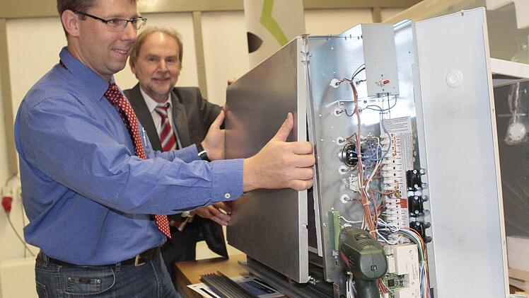 Die Dimplex-Ingenieure Nicolas Ostbomk (vorne) und Ewald Beckstein demonstrieren die Bauweise einer thermischen Speicherheizung. Foto: Jochen Nützel
