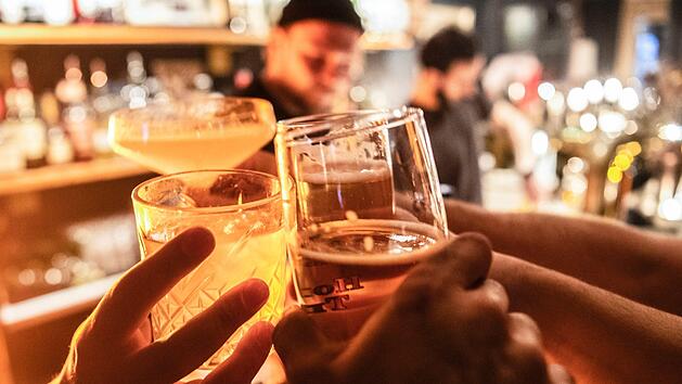 Gäste prosten sich in einer  Bar zu.  Ab Dienstag (17. März 2020)  dürfen diese und andere Freizeiteinrichtungen in Bayern vorerst nicht mehr öffnen. Foto: Paul Zinken / dpa