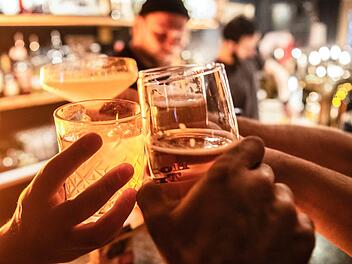 Gäste prosten sich in einer  Bar zu.  Ab Dienstag (17. März 2020)  dürfen diese und andere Freizeiteinrichtungen in Bayern vorerst nicht mehr öffnen. Foto: Paul Zinken / dpa