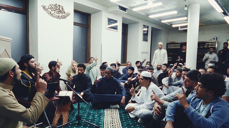 Prediger Abu Wala'a (Ibtasamm Shah, zweiter von links) unterrichtet seine Anh&auml;nger in der Moschee.