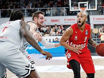 Maurice Stackey (rechts) hat den Korb im Blick, links der Würzburger Johannes Richter, vorne dessen Teamkollege Junior Etou. Foto:
