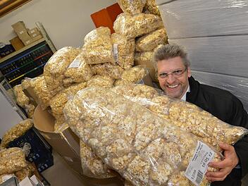 Kleine Tütchen in großen Tüten: Raimund Wörner mit dem Popcorn, das am Sonntag von den Wägen geworfen wird.  Fotos: Ronald Rinklef