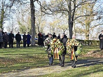 Gemeinsam mit Vertretern des VdK und des Kriegervereins legte Bürgermeister Claus Bittenbrünn (in der Mitte) zum Ende der Gedenkfeier am Ehrenmal Kränze nieder. Foto: Gerold Snater