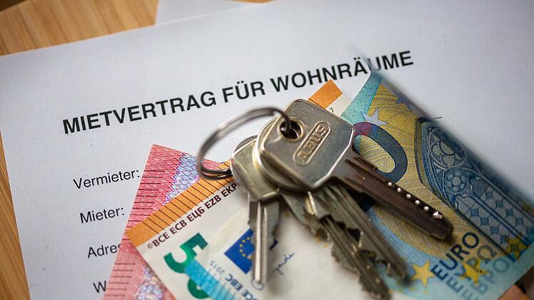 Mietvertrag, Geldscheine und Hausschl&uuml;ssel auf einem Tisch
