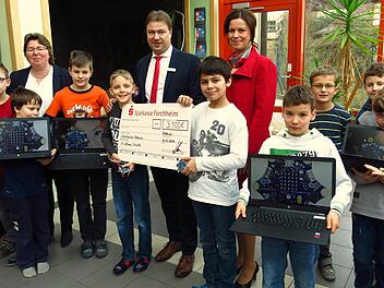 Bei der Feier in der Schule präsentieren die Schüler die neuen Rechner zusammen mit (von links)  Rektorin Silke Schür, Jürgen Klaus und Nicole Mainusch.  Die Calliope-Scheiben sind auf den Laptops abgebildet. Foto: Dagmar Niemann