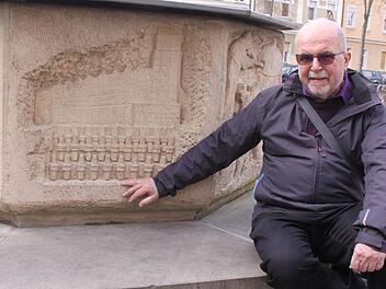 Hanns Steinhorst weiß, um was es sich bei diesen merkwürdigen Elementen auf dem Relief am Brunnen handelt.  Foto: Eva-Maria Bast