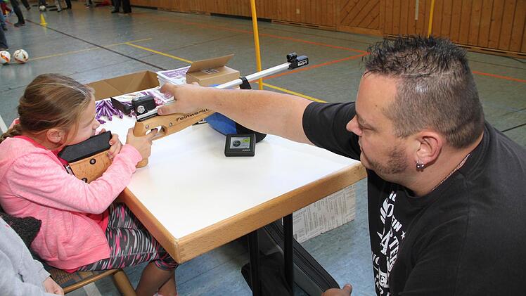 Markus Münch von der Zimmerstutzen-Schützengesellschaft Schwürbitz erklärt Fabrizia den Schießsport.