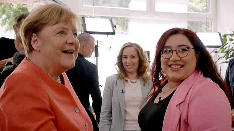 Ex-Bundeskanzlerin Angela Merkel (links) trifft sich zehn Jahre nach dem "Flüchtlingssommer" mit Menschen wie Mahsa Narimani (rechts), die damals aus dem Iran geflohen war und die seitdem in Deutschland lebt.