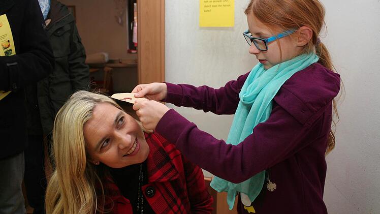 Clara zeigt Melanie Huml, dass auch ein Wurm Geräusche macht. Die Ministerin war einer der Festgäste auf dem Heinershof. Foto: Evi Seeger