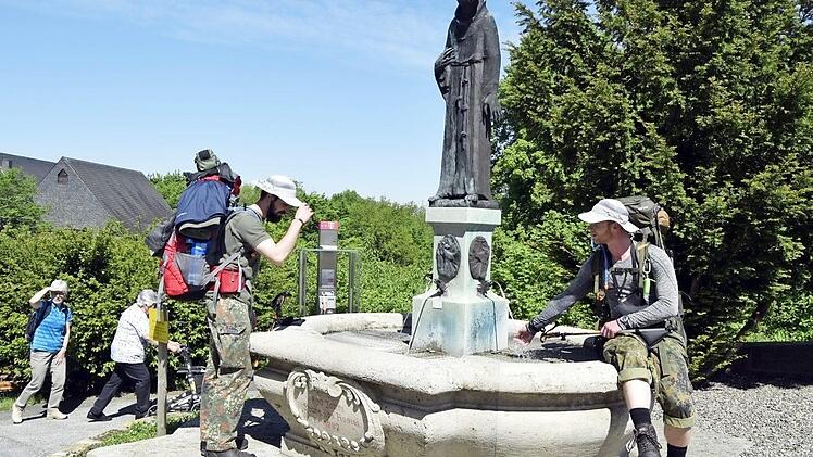 Zwei Wanderer aus Erfurt erfrischen sich am Franziskusbrunnen, den die Freunde und Förderer 2011 neu gestaltet haben. Foto: Andreas Welz