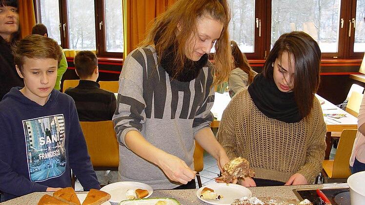 Oliver, Elmira und Nini bereiten das Frühstück, wobei die Mädchen Spezialitäten aus ihren Heimatländern mitbrachten. Foto: Brigitta Kempe-Wolf