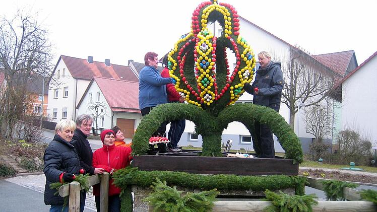 Fleißige Hände schmücken den Teuchatzer Osterbrunnen. Foto: Barbara Lunz