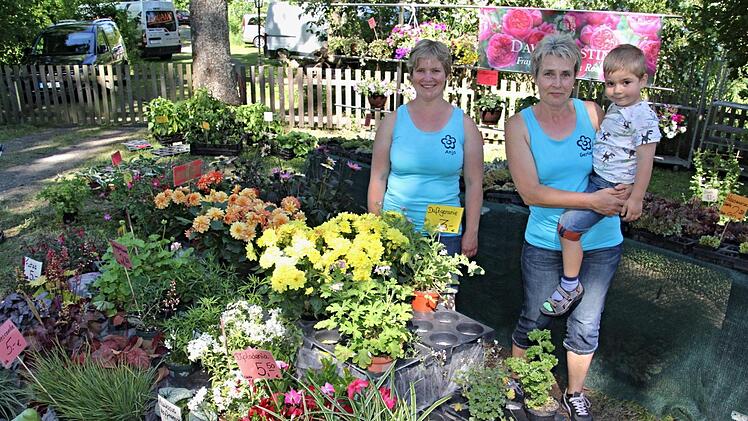 Anja Sperber und Gerlinde Schmitt mit ihrem Enkel (von links) bieten Blumen, Sträucher und Pflanzen der Gärtnerei Schmitt aus Unterpreppach an.