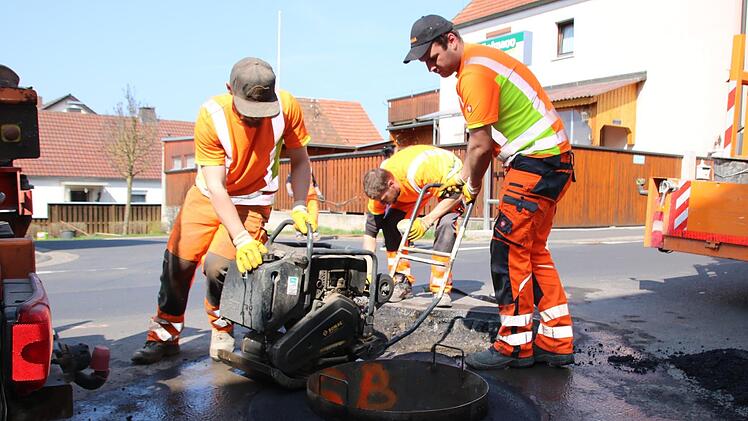 Bauleiter Stefan Etz und seine Kollegen sind ein eingespieltes Team: Während zwei Arbeiter vorne das Mischgut  für einen Kanaldeckel rütteln, wird hinten  die nächste Grube vorbereitet. Foto: Ralf Ruppert