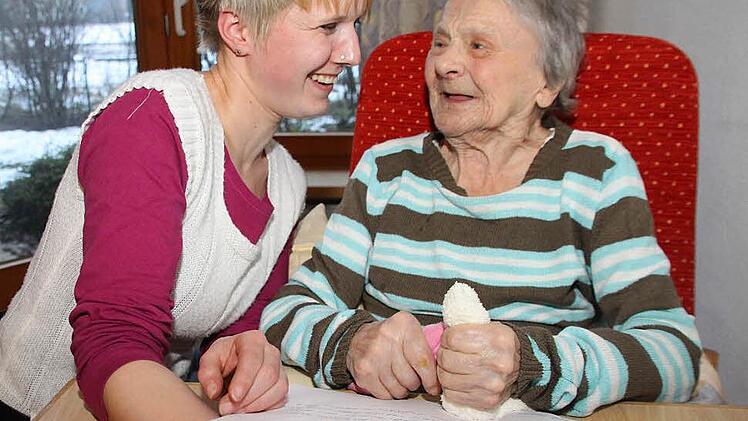 Ihre Palliativ-Care-Ausbildung hat Altenpflegerin Ines Koch geholfen, souveräner mit dem Thema Sterben umzugehen. Mit Ursula Ellermann schaut sie sich das Erinnerungsbuch für verstorbene Heimbewohner an. Zwei Seiten darin sind Ursula Ellermanns Mann Hans gewidmet, der bis November 2012 mit ihr im Awo-Pflegeheim in der Schützenstraße lebte.   Foto: Dagmar Besand