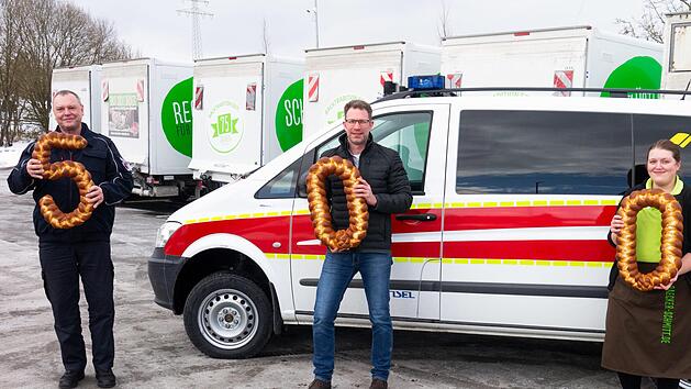 Bad Kissingens Stadtbrandinspektor Harald Albert (links) nahm die essbare Spendensumme über 500 Euro von Bäckereigeschäftsführer Johannes Schmitt (Mitte) und Bäckereifachverkäuferin Verena Simon entgegen. Foto: Foto:  Christine Weißenberger
