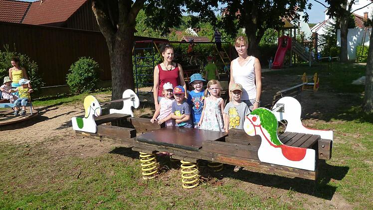 Eine Wippe in der Wiesenau gestalteten die Kindergartenkinder unter ihrer Leiterin Carola Wells (links) mit neuer Farbe. Foto: Stefan Geiger