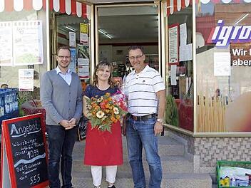 Igros-Repräsentant Heiko Vöth (links) und Bürgermeister Thomas Hack (rechts) dankten Betreiberin Gülin Zeisberg (Mitte) für ihr Engagement im Dorfladen mit Blumen.  Foto: Winfried Ehling