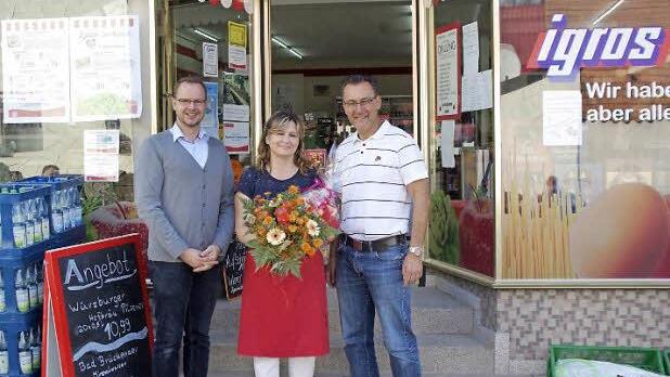 Igros-Repräsentant Heiko Vöth (links) und Bürgermeister Thomas Hack (rechts) dankten Betreiberin Gülin Zeisberg (Mitte) für ihr Engagement im Dorfladen mit Blumen.  Foto: Winfried Ehling