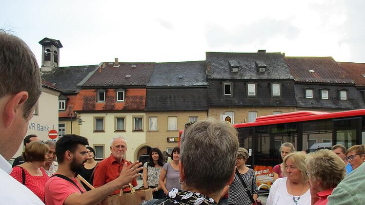 Das mittelalterliche Stadtsteinach auf der Rathausseite ist 1798 abgebrannt. Die jetzige Form der engen und gleichförmigen Bebauung (im Hintergrund) stammt aus dem frühen 19. Jahrhundert. NIcki Lang (links) und Wolfgang Martin (in roten Hemden) führten erstmals durch Stadtsteinach innerhalb der Stadtmauer. Foto: Klaus Klaschka