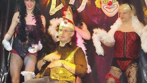 Die Männer-Tanzgruppe umgarnt Conférencier Georg Fischer (Mitte).