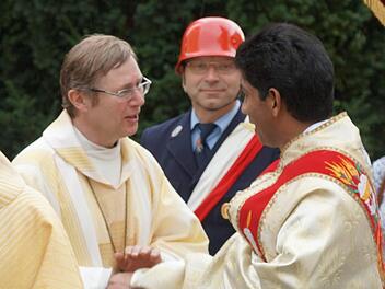 Pater Charles (rechts) nimmt die guten Wünsche der kirchlichen Würdenträger entgegen. Foto: Johannes Michel