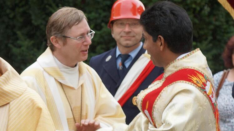 Pater Charles (rechts) nimmt die guten Wünsche der kirchlichen Würdenträger entgegen. Foto: Johannes Michel