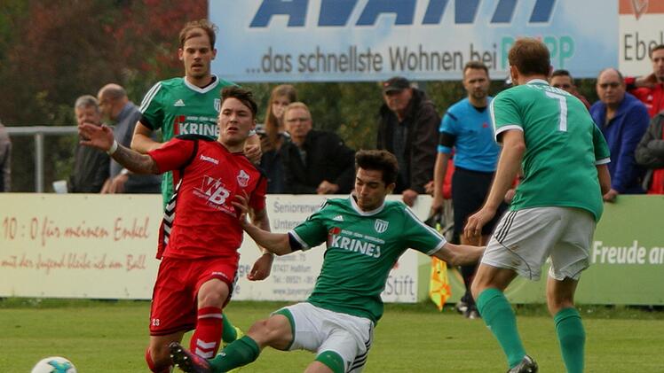 Der Sander Adrian Reith (Zweiter von rechts), Torschütze zum 1:1-Ausgleich, grätscht  dem Aubstadter Ingo Feser in den Ball. Die Sander Andre Karmann (rechts) und Sebastian Wagner (links) verfolgen die Szene.