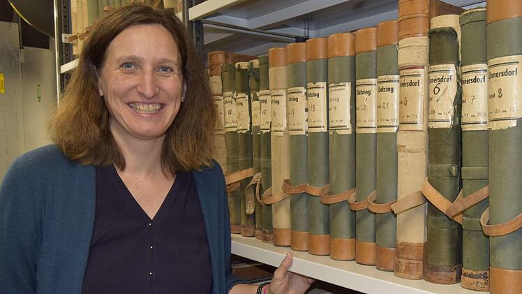 Christine Pflaum vor Grundbüchern, die teilweise restauriert wurden.
