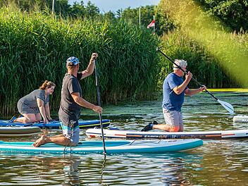 Ab ins Wasser und rauf aufs Board: Der Trendsport Stand-up-Paddling wird auch am Sander Baggersee angeboten. Foto: Julia Scholl