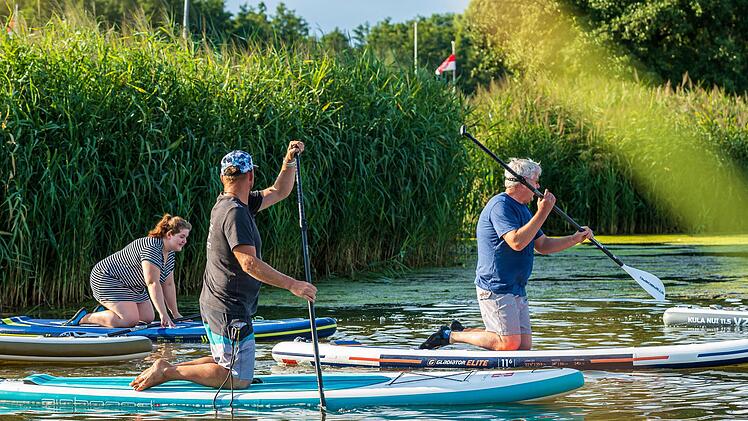 Ab ins Wasser und rauf aufs Board: Der Trendsport Stand-up-Paddling wird auch am Sander Baggersee angeboten. Foto: Julia Scholl
