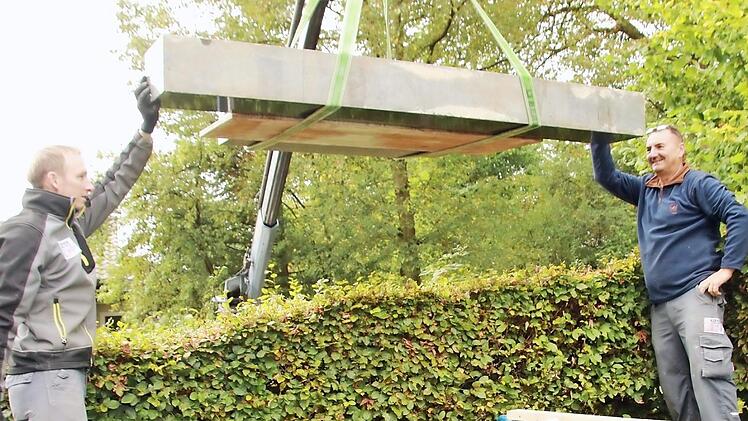 Thomas Dinkel (links) und Wolfgang Zillig von der Staffelsteiner Steinmetzfirma Kerner setzen einen Grabstein im Draisdorfer Friedhof, nachdem die Inschrift neu vergoldet worden ist. Fotos: Matthias Einwag