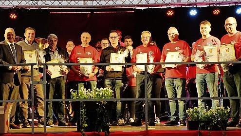 Dirigent Frank Macht (Mitte) und sieben Mitglieder sind Ehrentitel verliehen worden.