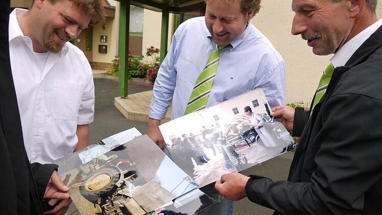 Stephan Spitzer, Bernd Friedrich und Rudolf Groß schauen sich alte Fotos von MR-Aktivitäten an. Eine Spezialmaschine besaß der Verein: Eine Art Hebebühne , damit Kühen die Klauen sicher geschnitten werden konnten.