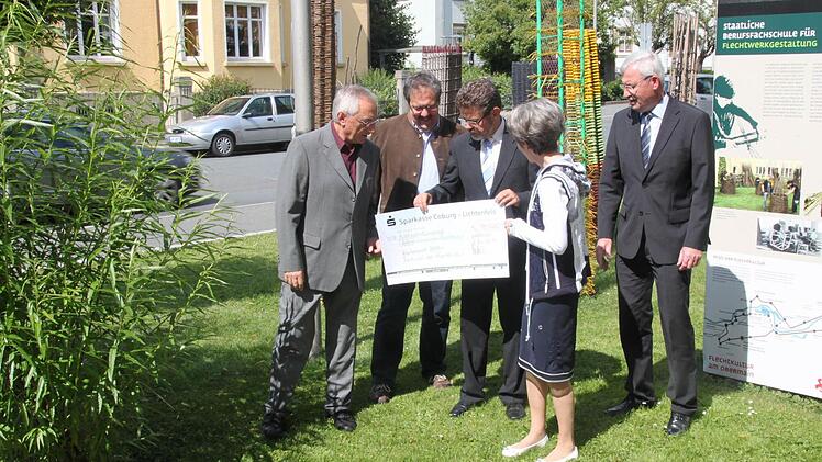 Scheckübergabe vor der Berufsfachschule für Flechtwerkgestaltung, von links Josef Breunlein und Manfred Rauh, die sich im Verein Zentrum Europäischer Flechtkultur um die Highlights im Korbmarkt-Programm kümmern, Direktor Siegfried Wölki und Walter Partheymüller von der Sparkasse, vorne Bürgermeisterin Bianca Fischer, die sich für diese außergewöhnliche finanzielle Unterstützung - 18 000 Euro - herzlich bedankte. Foto: Popp
