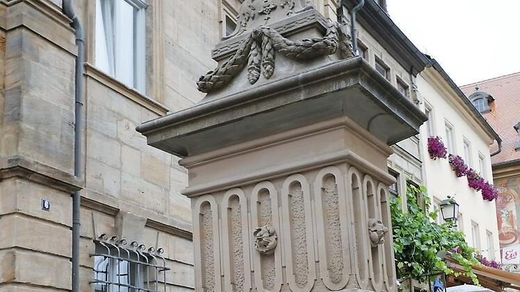Stadtwerke-Mitarbeiter Michael Schneider beim Anbringen des Schildes "Trinkwasser" am Adlerbrunnen Foto: Stadtwerke