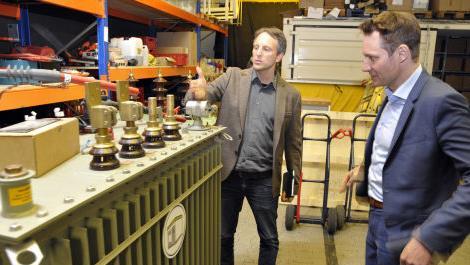 Firmenchef Mario Münch zeigt dem Fraktionsvorsitzenden von Bündnis 90/Die Grünen im Landtag, Ludwig Hartmann,  einen hocheffizienten Transformator, der Münch zufolge nur äußerst geringe Energieverluste hat. Foto: privat