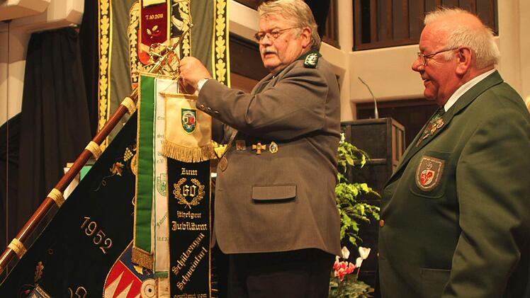 Gauschützenmeister Dieter Koch (links) beim Anhängen des Fahnenbandes, das von Siegfried Redker aus Dortmund-Scherte überreicht wurde.