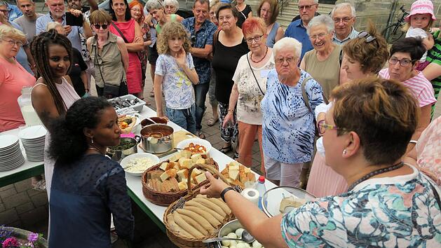 Mit Unterst&uuml;tzung von Maria Hollering-Hamers (rechts) kl&auml;rten Tigist und Meroun aus &Auml;thiopien &uuml;ber die Sitten und Gebr&auml;uche rund um das Nationalgericht Doro Wot auf, bevor sie den Besuchern des "Sommerfests der Begegnung" Kostproben servierten Foto: Joachim Wegner
