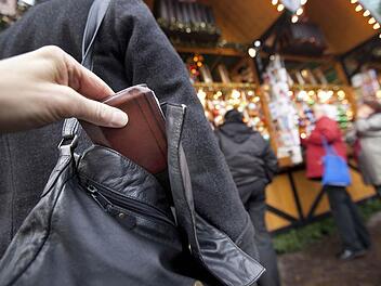 Dass die Szene auf dem Weihnachtsmarkt gestellt ist, erkennt man sofort: Ein Profi würde eine zusamengefaltete Zeitung oder ein Kleidungsstück über die so genante Ziehhand halten. Foto: dpa