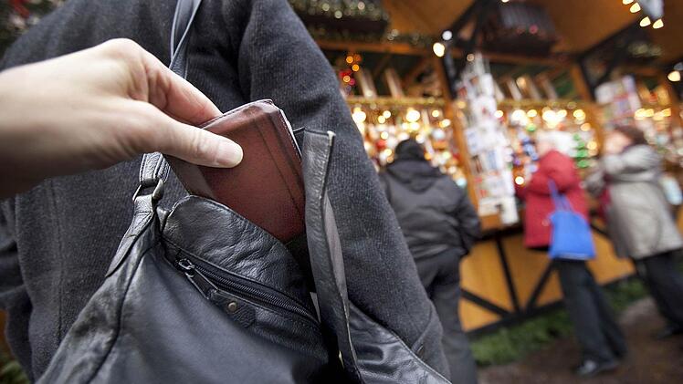Dass die Szene auf dem Weihnachtsmarkt gestellt ist, erkennt man sofort: Ein Profi würde eine zusamengefaltete Zeitung oder ein Kleidungsstück über die so genante Ziehhand halten. Foto: dpa