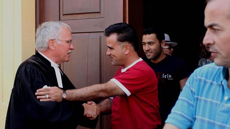 Herzliche Umarmung von Pfarrer Volkmar Gregori (links) durch Zen Aldeen Mahmoud (2. Von links). Foto: Günther Geiling