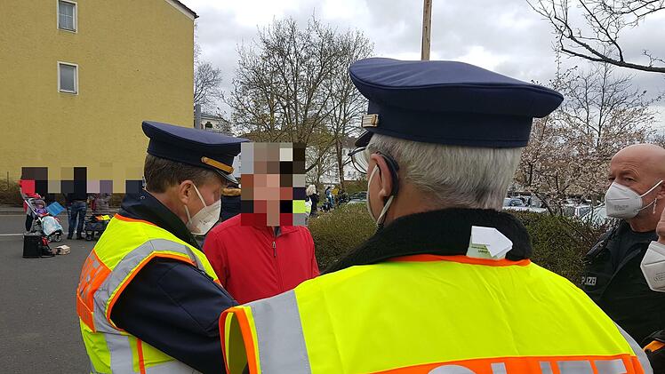Johann Fischer (Name geändert) steht unmaskiert zwischen zwei Polizisten. Links im Bild Dienststellenleiter Stefan Haschke. Foto: Susanne Will