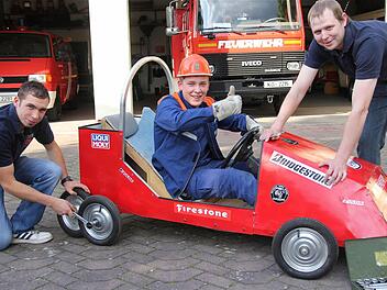 Im Vorfeld des Rennens hat die Feuerwehrjugend ihr Feuerwehrhaus zur Boxengasse gemacht und fleißig an den Seifenkisten geschraubt: (Von links) Tim Englert, Julian Keller und Matthias Heid. Foto: Gerd Schaar