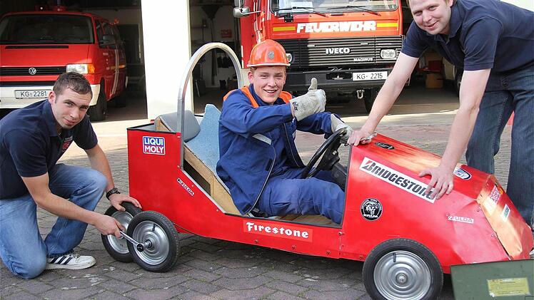 Im Vorfeld des Rennens hat die Feuerwehrjugend ihr Feuerwehrhaus zur Boxengasse gemacht und fleißig an den Seifenkisten geschraubt: (Von links) Tim Englert, Julian Keller und Matthias Heid. Foto: Gerd Schaar