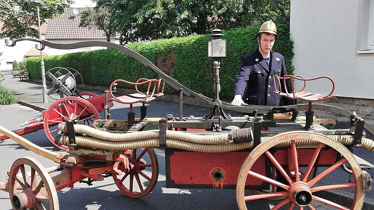 Diese historische Handdruckspritze von 1893 mit  Feuerwehrmann in der zur Zeit passenden Uniform  gab es unter anderem  bei der Ausstellung historischer Fahrzeuge anlässlich des 140-jährigen Jubiläums der Freiwilligen feuerwehr Reichenbach zu sehen. Foto: Sigismund von Dobschütz