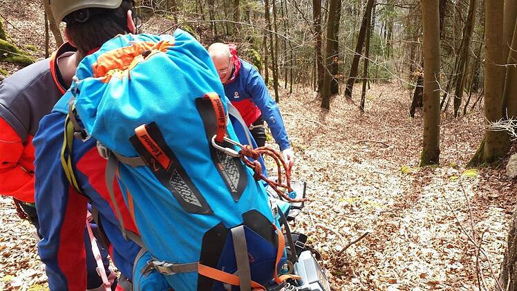Im Beisein des Notarzt lassen zwei Bergretter den Verunglückten mittels einer Gebirgstrage gesichert ab.Foto: Bergwacht