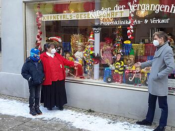 Der Bad Brückenauer Karneval findet heuer im Schaufenster statt. Puppendoktor Olaf Zieseniß (rechts), Vereinsvorsitzende Manuela Word und der elfjährige Jason Just von den Roten Funken freuen sich über die kurzfristig realisierte Präsentation.  Foto: Rolf Pralle