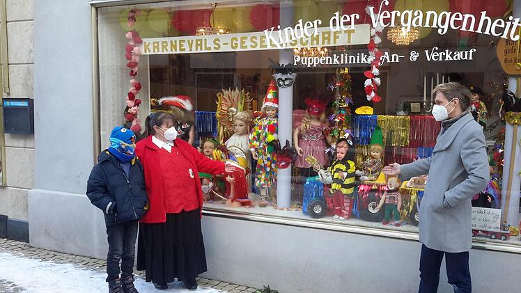 Der Bad Brückenauer Karneval findet heuer im Schaufenster statt. Puppendoktor Olaf Zieseniß (rechts), Vereinsvorsitzende Manuela Word und der elfjährige Jason Just von den Roten Funken freuen sich über die kurzfristig realisierte Präsentation.  Foto: Rolf Pralle